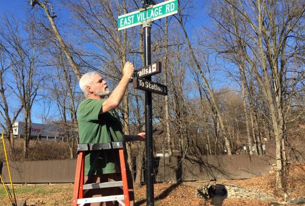Trail Conference Volunteer installing new signs in Tuxedo, N.Y.